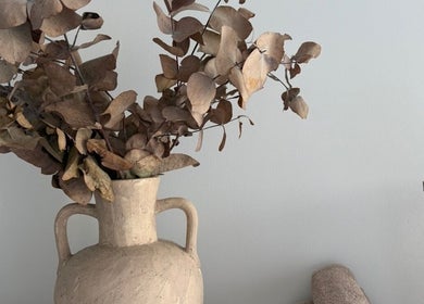 Rustic vase with dried leaves decorates Body Therapy Studio, Melbourne, Victoria, AU, for a serene ambiance.