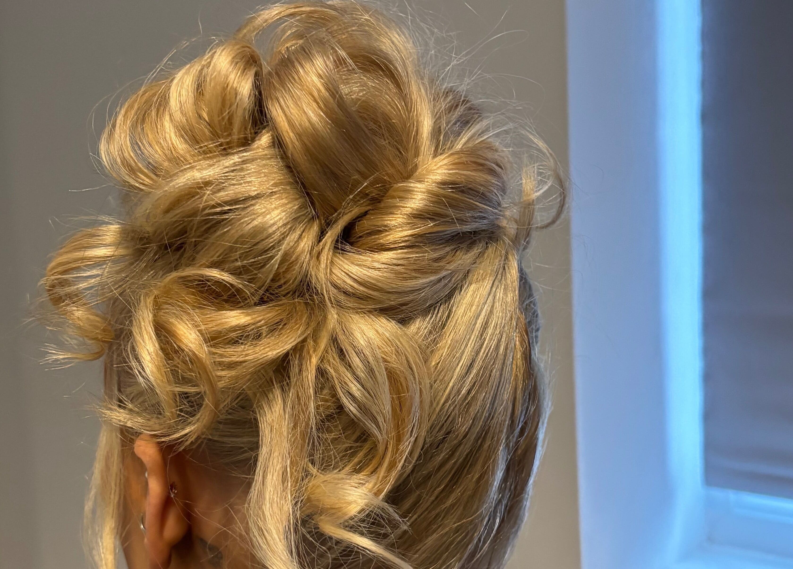 Stylish updo hairstyle at Revamp Studios in Ashington, England, GB, showcasing expertly styled blonde curls.