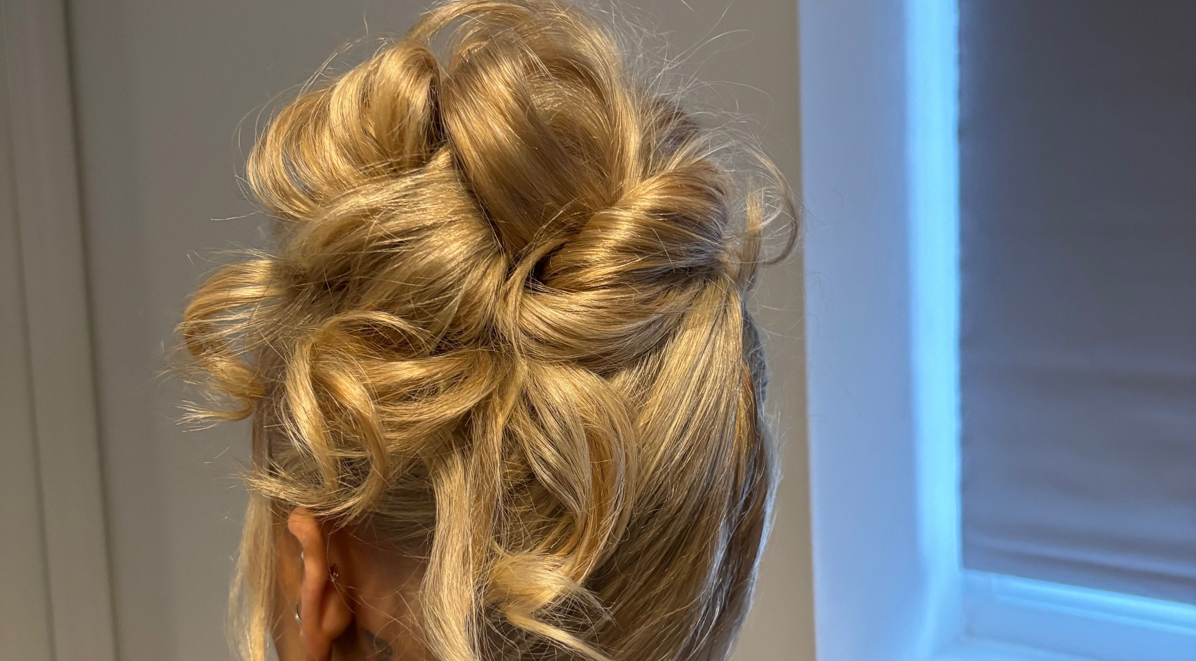 Stylish updo hairstyle at Revamp Studios in Ashington, England, GB, showcasing expertly styled blonde curls.