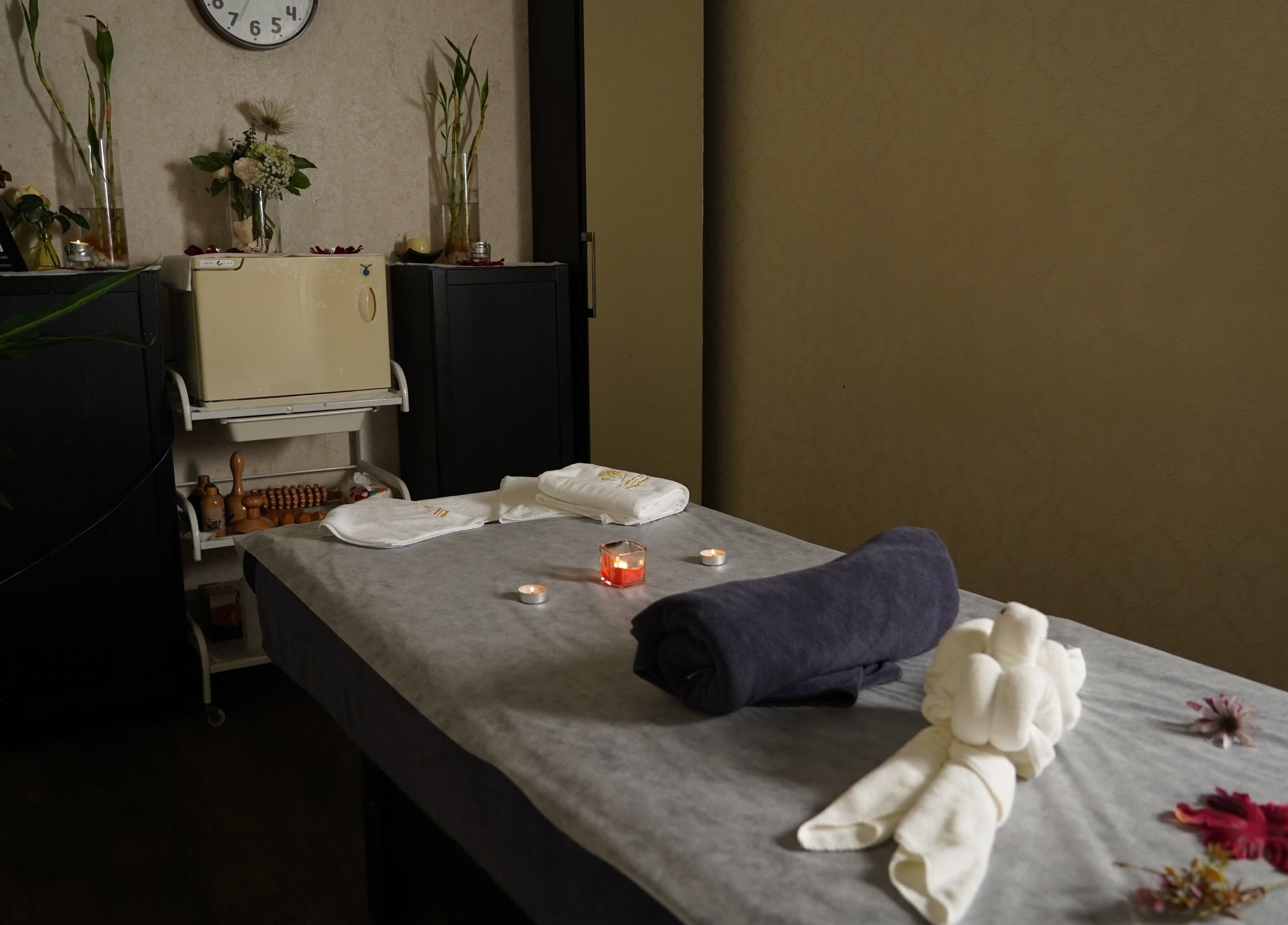 Massage room at Maid Hassan Beauty Center in Tarut, Eastern Province, SA, with candles and flowers.