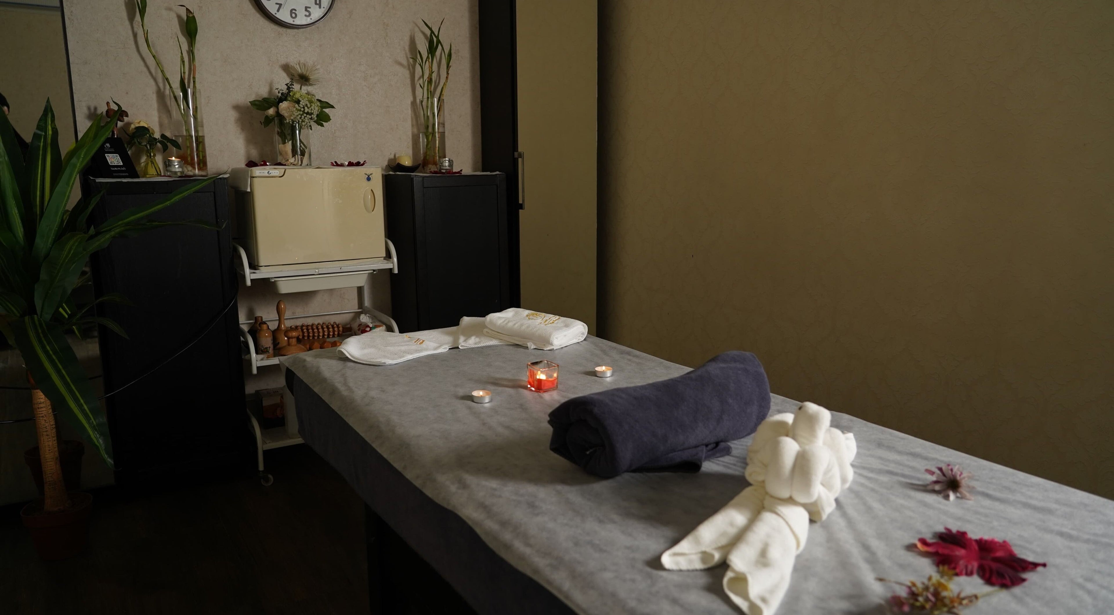 Massage room at Maid Hassan Beauty Center in Tarut, Eastern Province, SA, with candles and flowers.