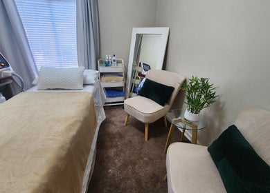 Cozy treatment room at barewithtea_laser_studio, Randburg, Gauteng, ZA, with a plush bed and modern decor.
