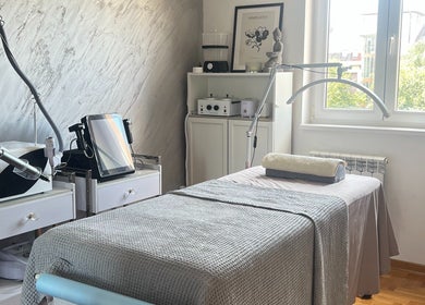 Serene treatment room at Adore Me Beauty Studio, Beograd, RS, with equipment and a cozy bed.