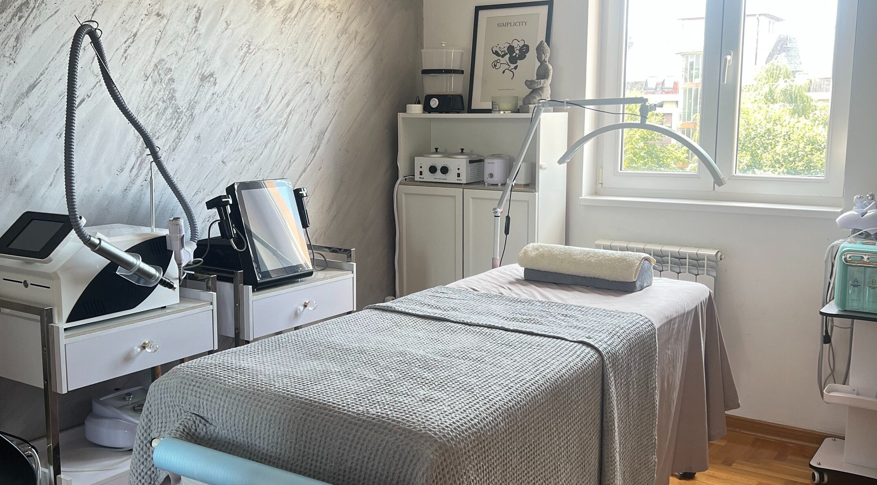 Serene treatment room at Adore Me Beauty Studio, Beograd, RS, with equipment and a cozy bed.