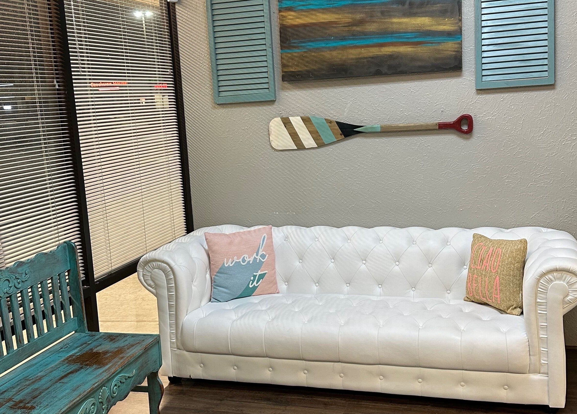 Inviting lounge area with white tufted sofa at The Wave Salon, Broken Arrow, Oklahoma, US.