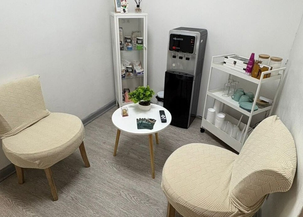 Acogedor salón de espera en Footvital, Maipú, Región Metropolitana, CL, con sillas y mesa decorativa.