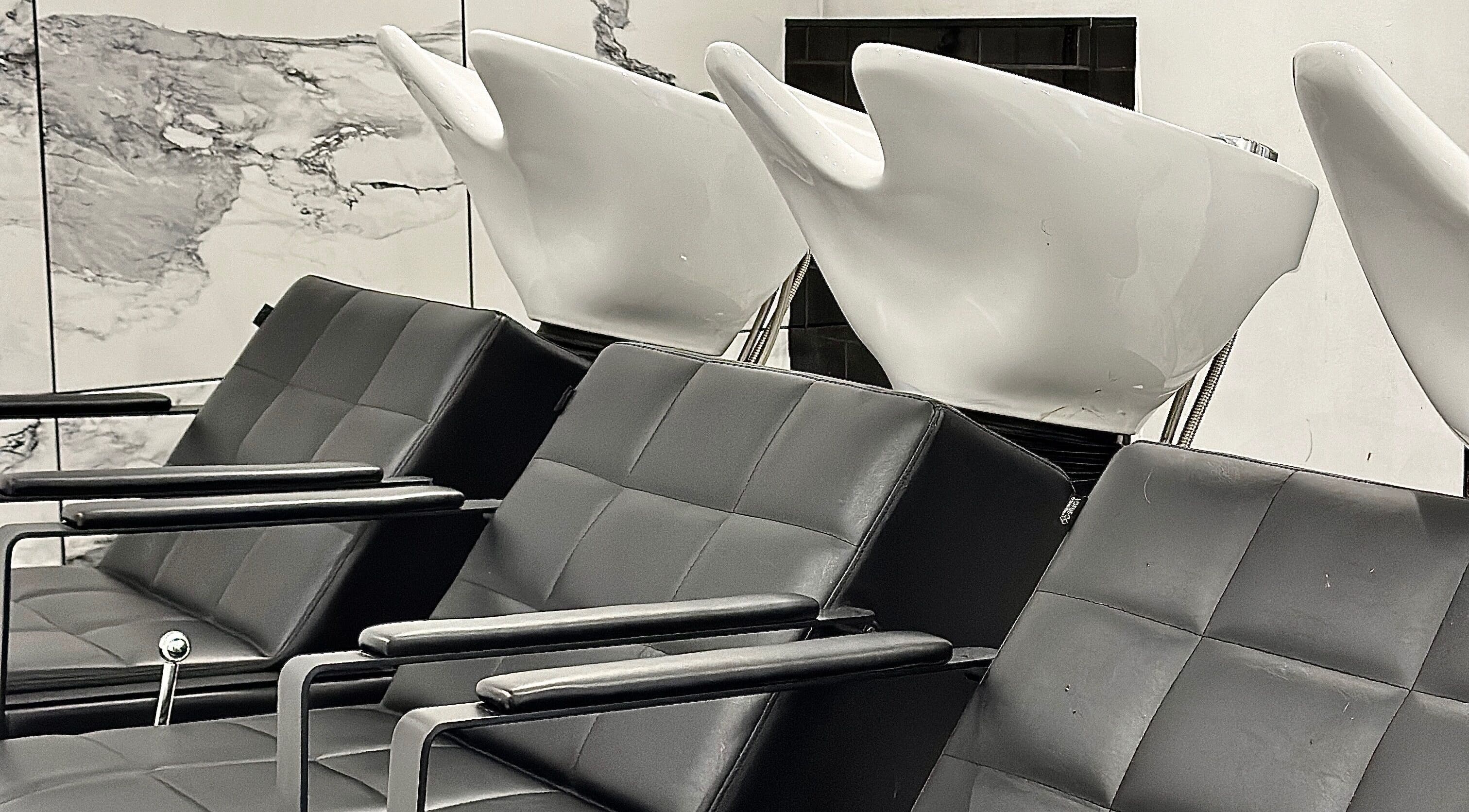 Modern wash stations at SHADE ANDOVER, Andover, England, GB. Sleek black seating with white basins.
