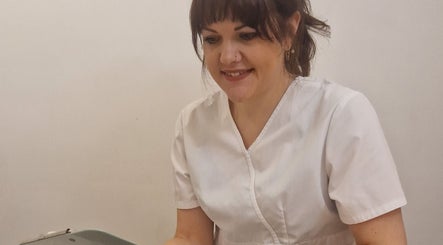 Smiling therapist at Katie Betty Laser & Aesthetics, Portsmouth, England, GB in a white uniform.