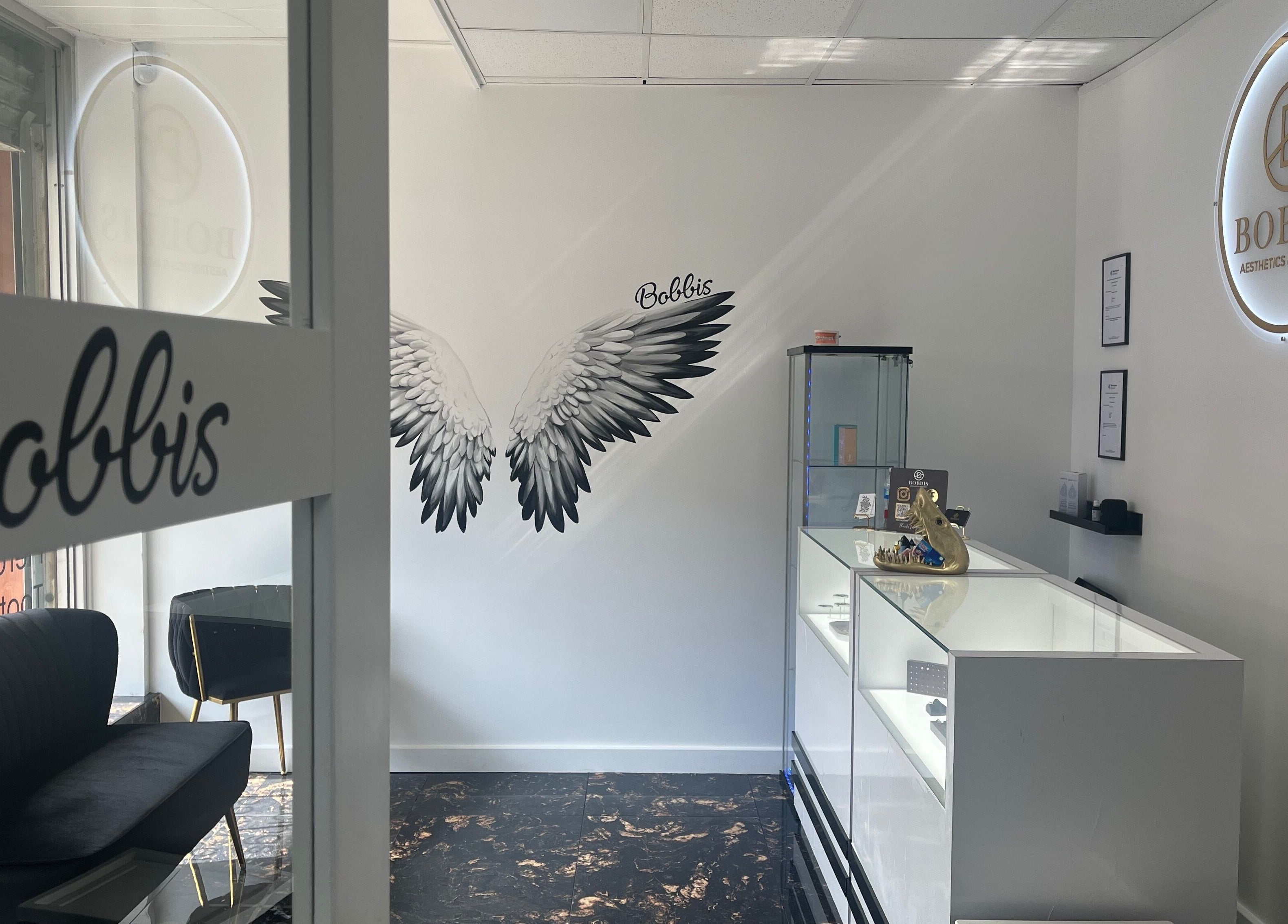 Interior of Bobbi's Aesthetics & Piercing in Bletchley, England, featuring chic seating and modern design.