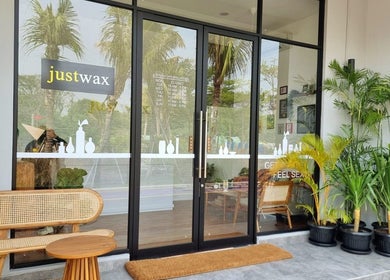 Entrance of Justwax PIK in Daerah Khusus Ibukota Jakarta showcasing modern decor and lush greenery.