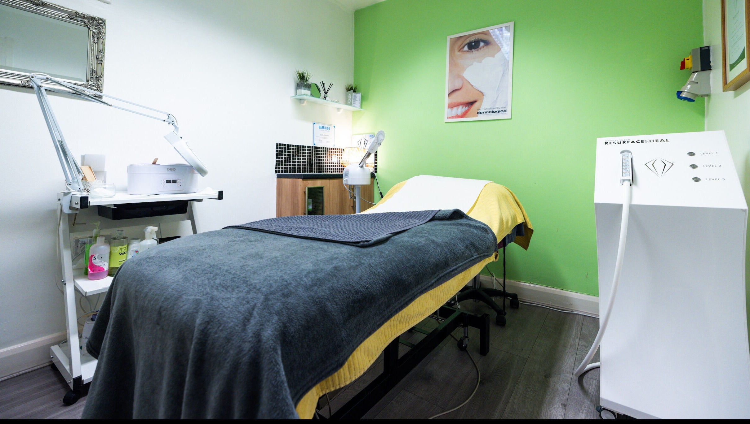 Relaxing treatment room at Beauty Plus in London, England, GB, featuring modern equipment and green accent wall.
