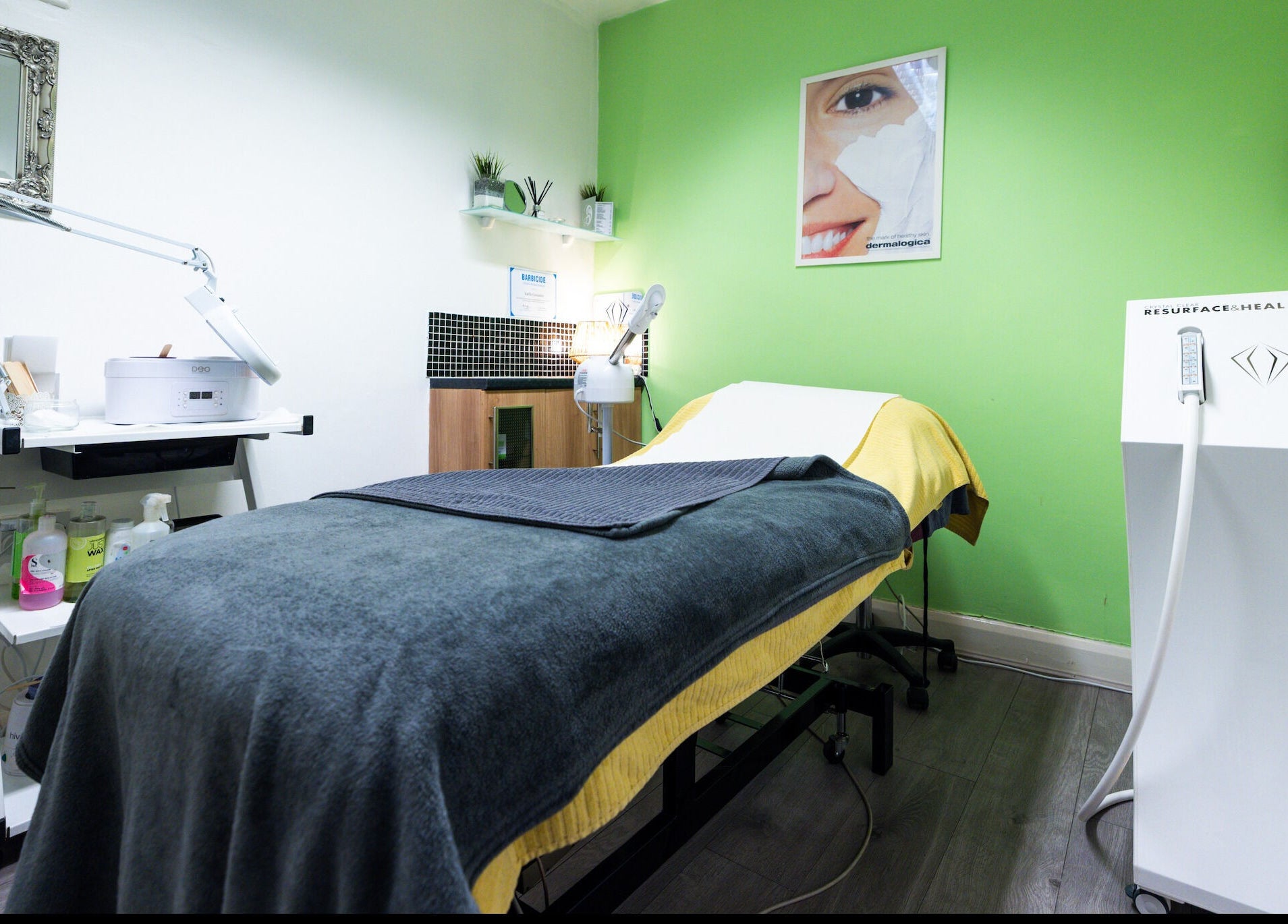 Relaxing treatment room at Beauty Plus in London, England, GB, featuring modern equipment and green accent wall.