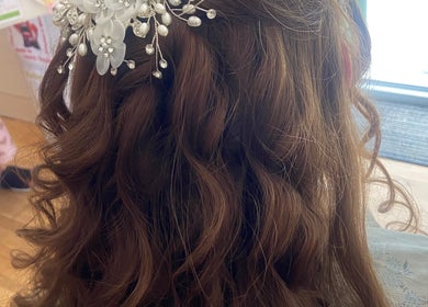 Intricate curled hairstyle with floral accessories at Powder Beauty At Duke House, Brighton, England, GB.