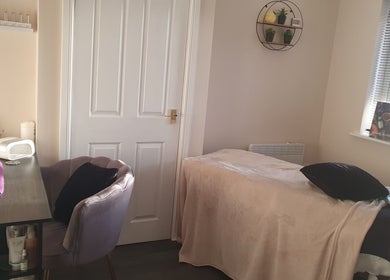 Cozy therapy room at Bare Faced Beauty by Charlie in Helsby, England, GB, featuring a treatment bed and nail station.