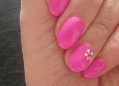 Bright pink nails with floral design at Bare Faced Beauty by Charlie in Helsby, England, GB.
