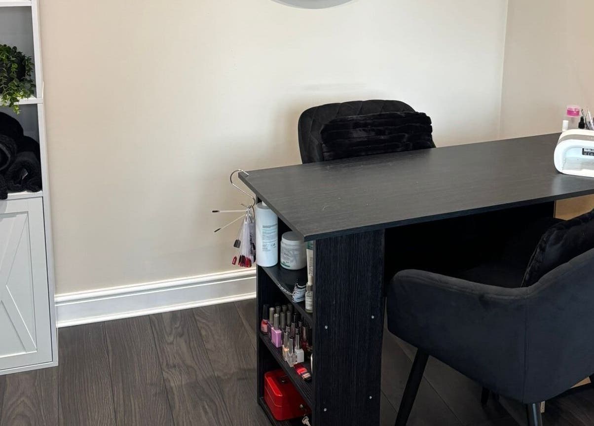 Nail salon desk at BareFaced Beauty by Charlie, Helsby, England, GB, showcasing plush seating and tools.
