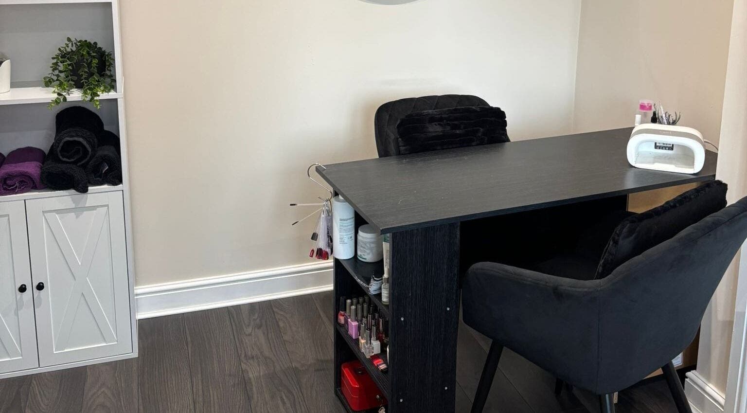 Nail salon desk at BareFaced Beauty by Charlie, Helsby, England, GB, showcasing plush seating and tools.