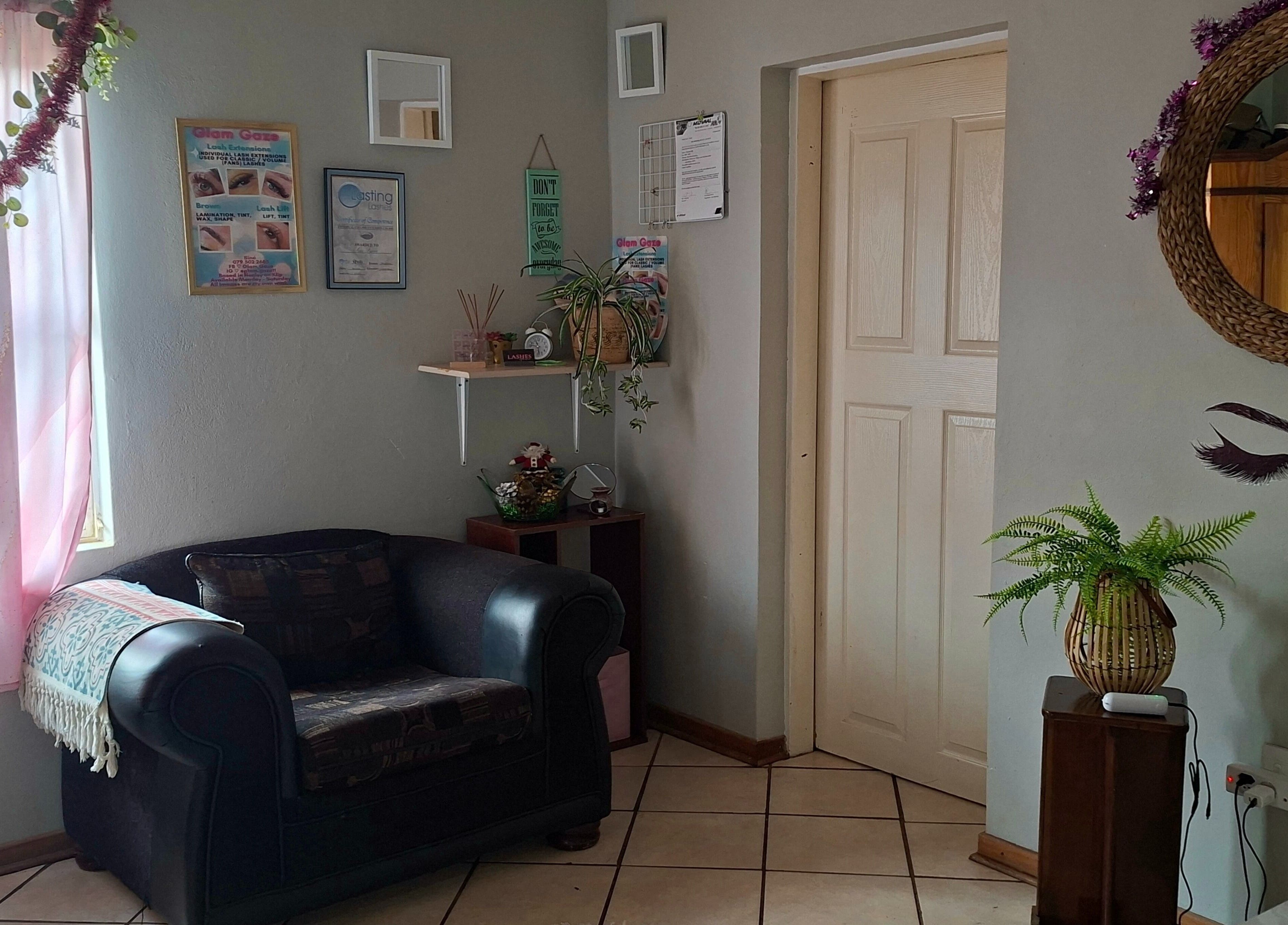 Inviting lounge area at Glam Gaze, Meyerton, Gauteng, ZA, featuring stylish decor and a comfy armchair.