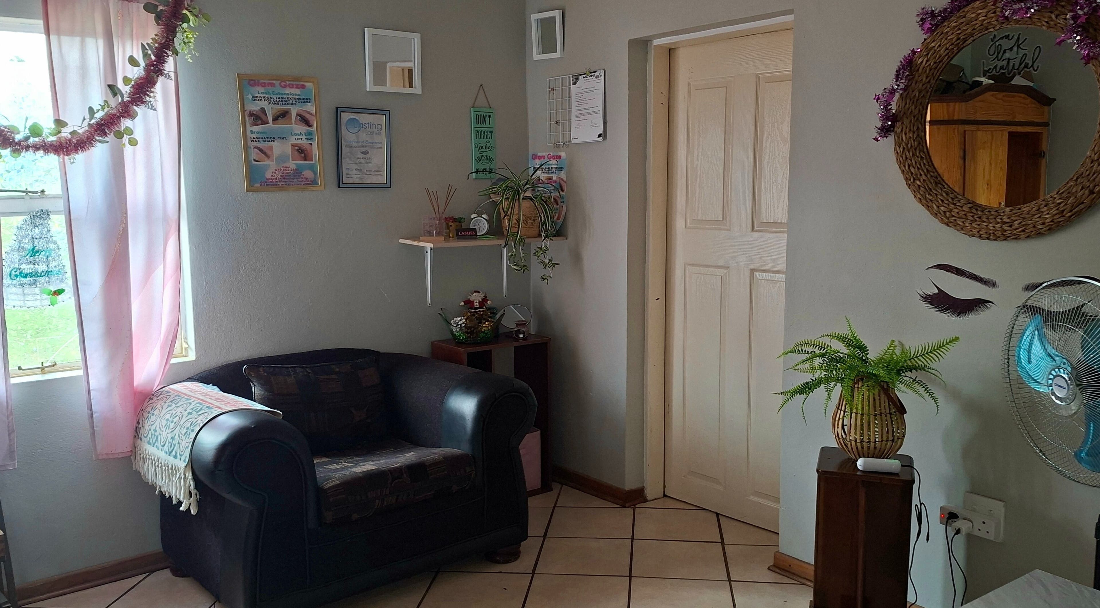 Inviting lounge area at Glam Gaze, Meyerton, Gauteng, ZA, featuring stylish decor and a comfy armchair.