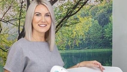 Professional specialist smiling at AKBrows - Richmond, set against a calming nature backdrop. Richmond, England, GB.