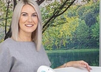 Professional specialist smiling at AKBrows - Richmond, set against a calming nature backdrop. Richmond, England, GB.