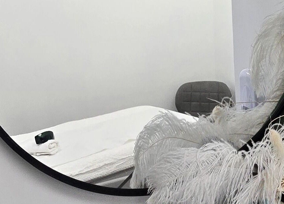 Elegant treatment room with mirror at AK Laser Beauty & Brows, Accrington, England, GB, featuring a cozy setup.