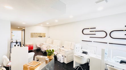 Chic nail salon interior at Sparadise, Calgary, Alberta, CA, featuring plush white chairs and modern decor.