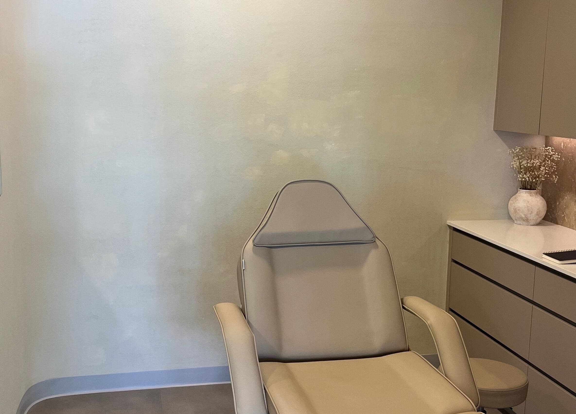 Tranquil treatment room at Nadine Aesthetics, Pacific Pines, Queensland, AU with modern chair and decor.