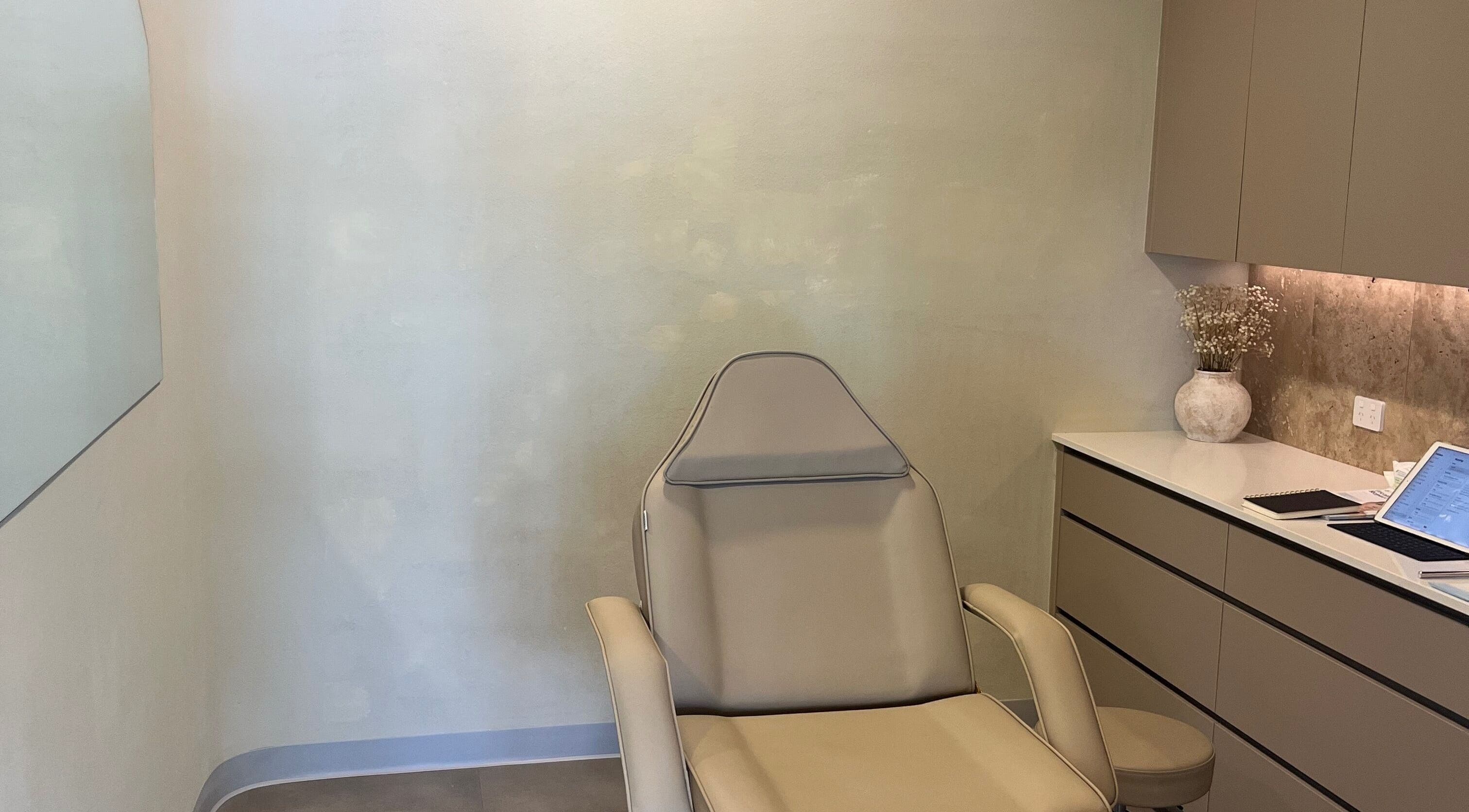 Tranquil treatment room at Nadine Aesthetics, Pacific Pines, Queensland, AU with modern chair and decor.