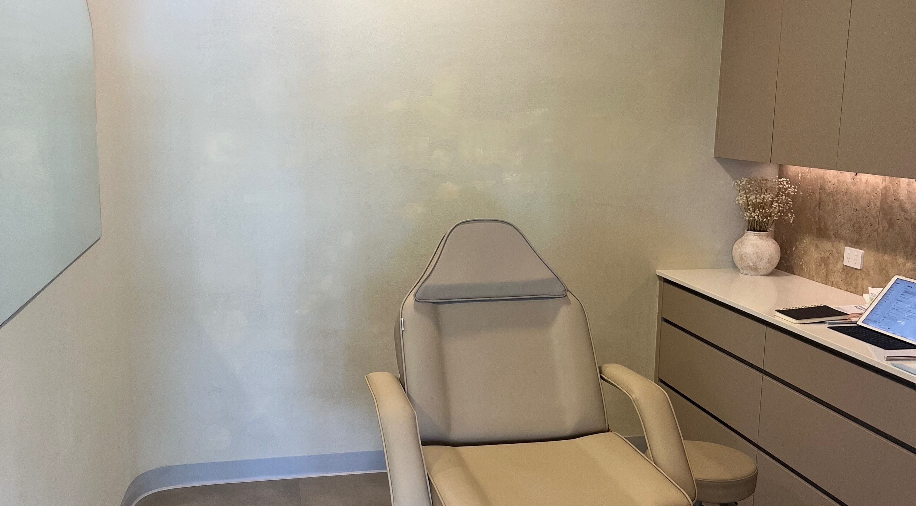 Tranquil treatment room at Nadine Aesthetics, Pacific Pines, Queensland, AU with modern chair and decor.