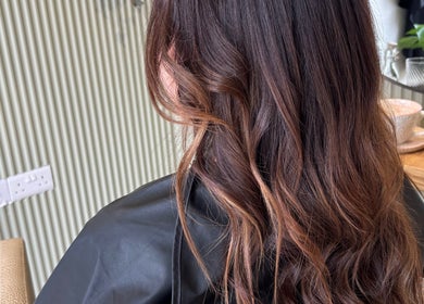Long, wavy brunette hair styled at Hannah Marie Hair Studio, Hurstbourne Tarrant, England, GB.