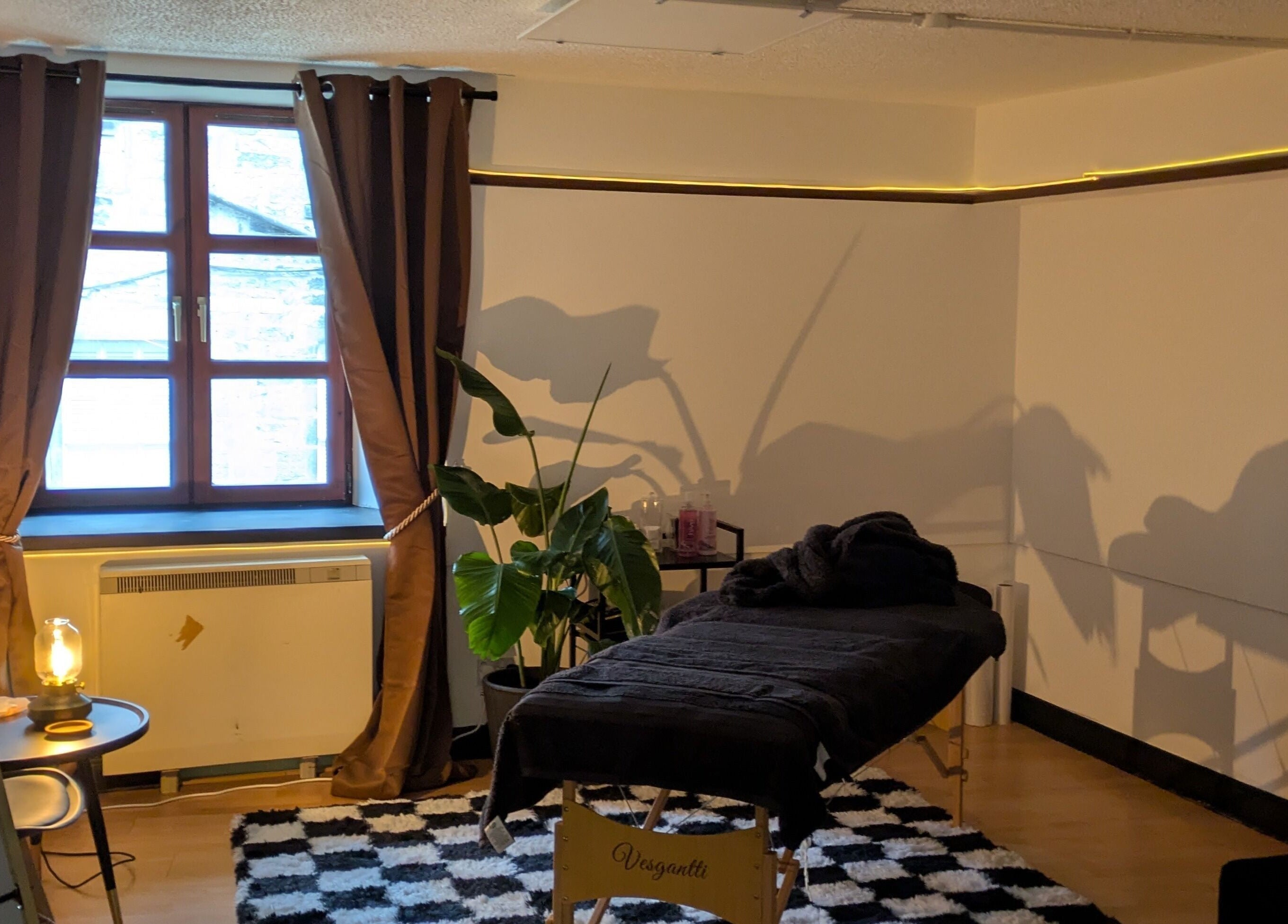 Relaxing massage room at Claws and Pause, Edinburgh, Scotland, GB, with cozy decor and natural lighting.