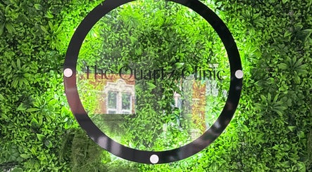 The Quartz Clinic sign set against a lush green wall in Hucknall, England, GB.