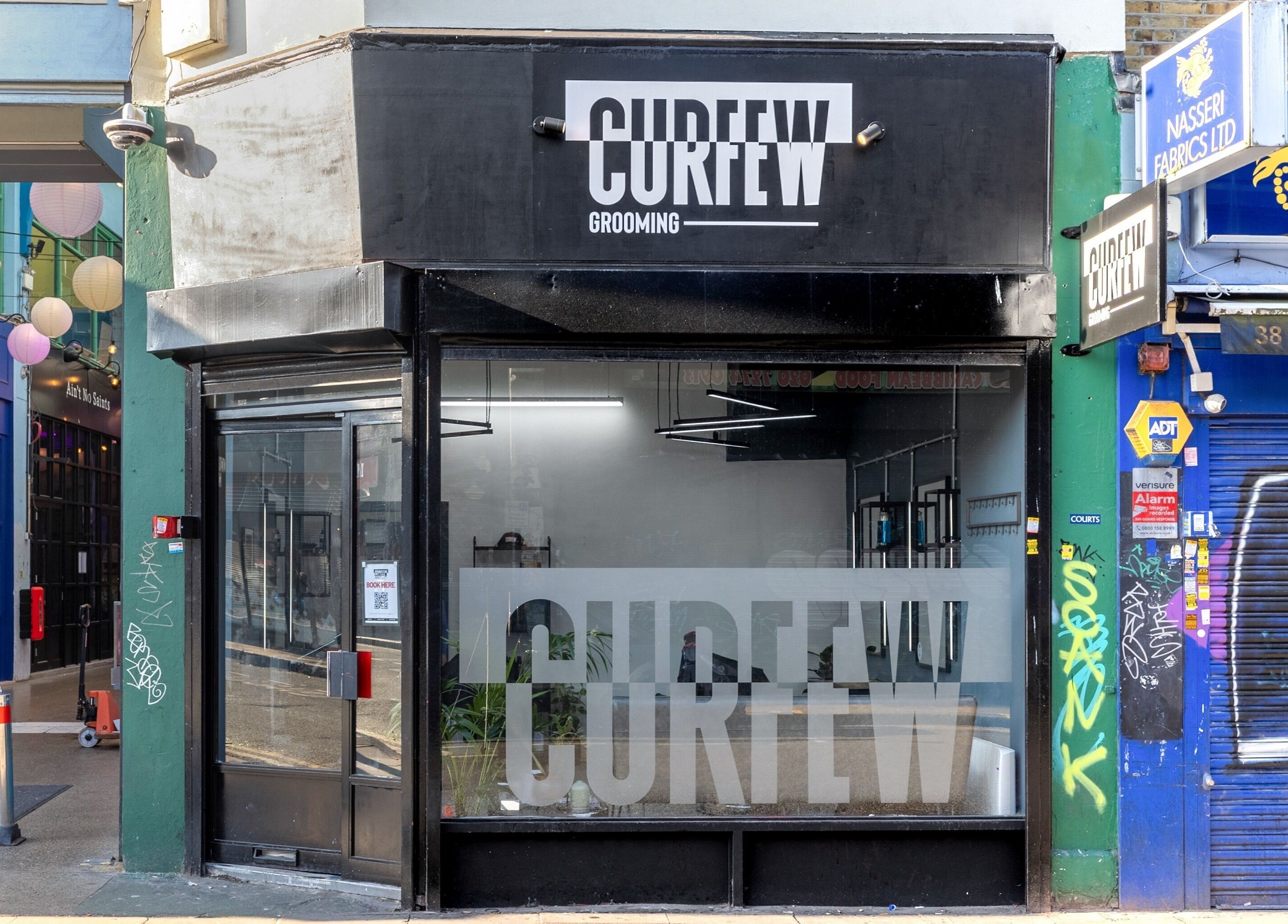 Entrance of Curfew Grooming Brixton, a sleek barbershop in London, England, GB, showcasing a modern design.