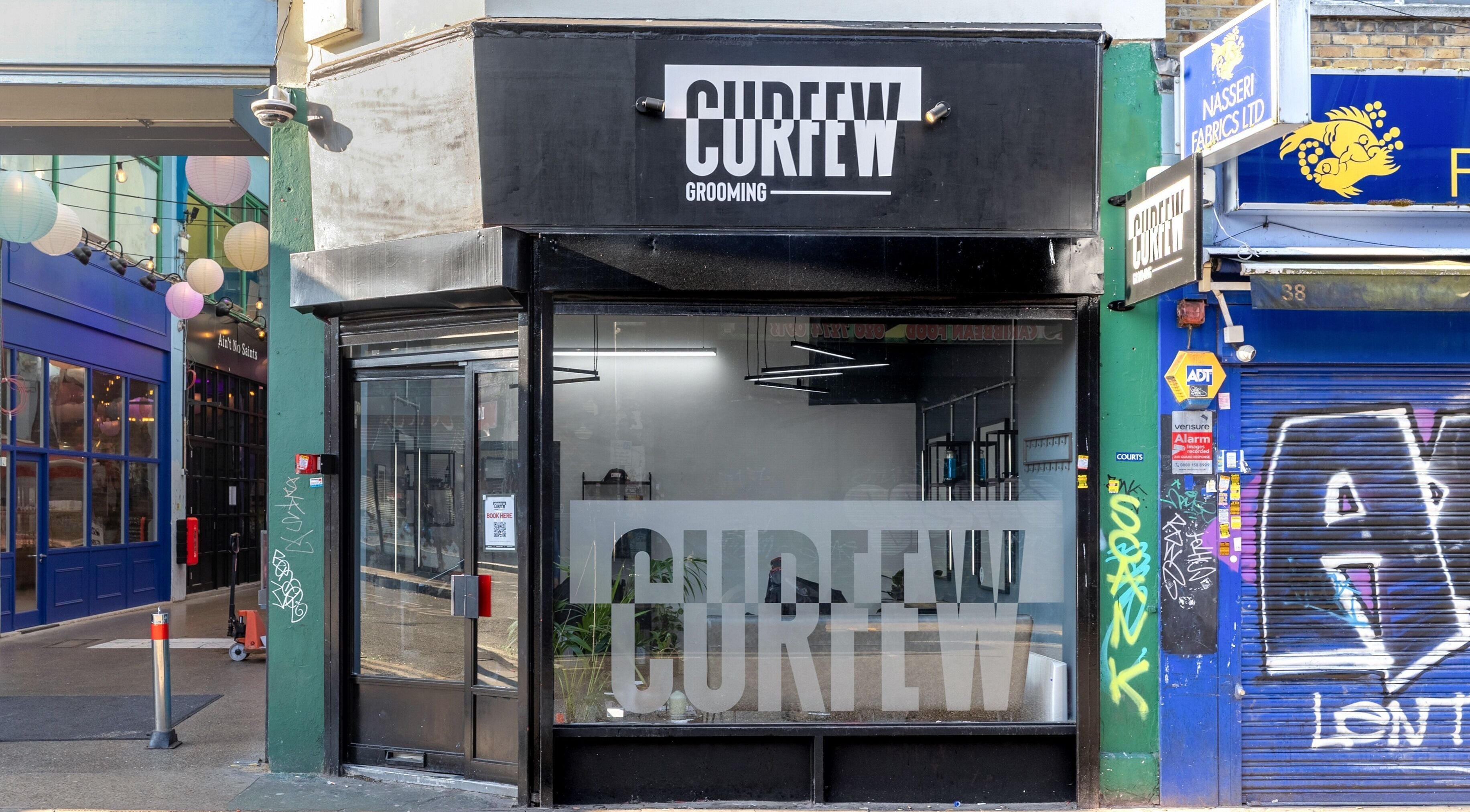 Entrance of Curfew Grooming Brixton, a sleek barbershop in London, England, GB, showcasing a modern design.