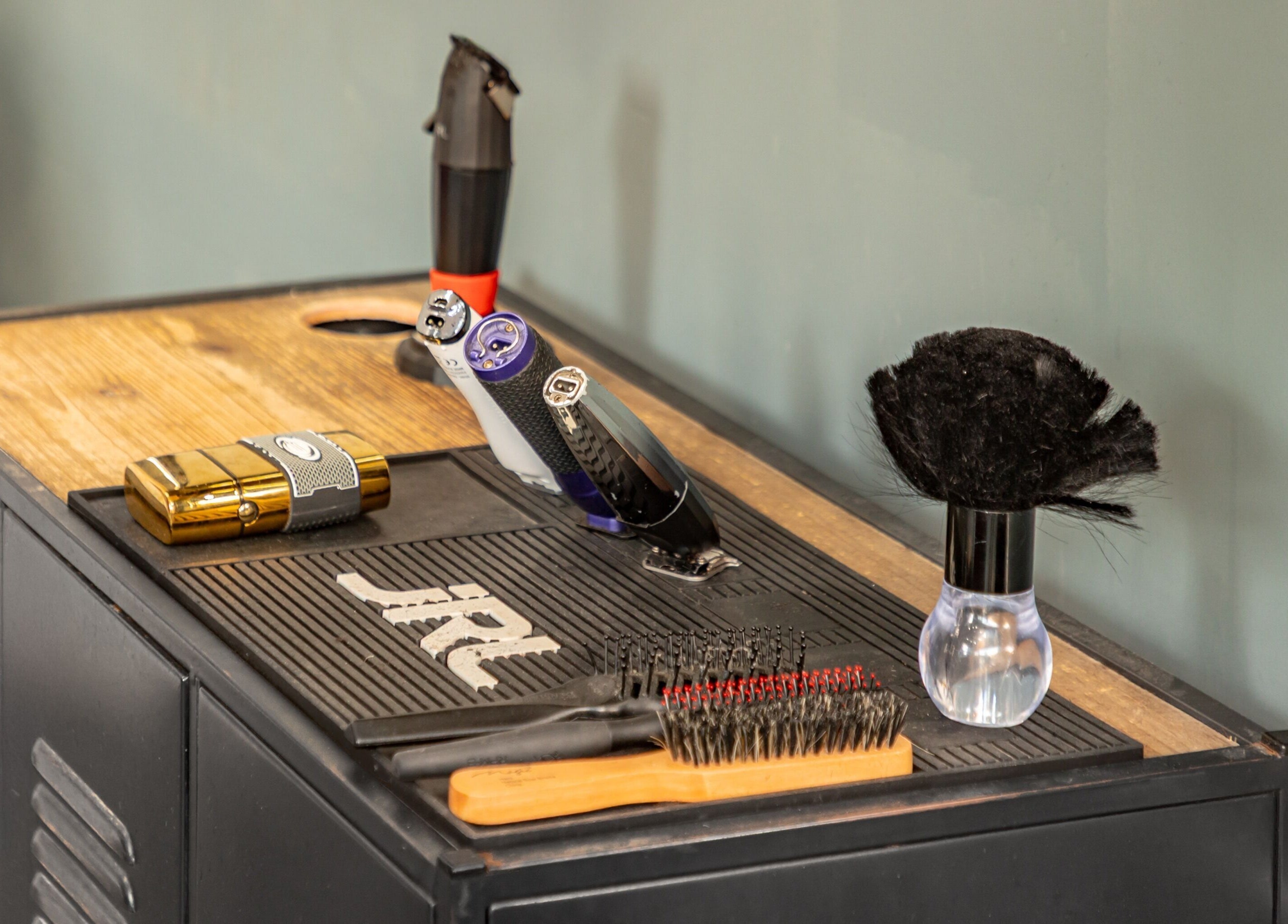 Curfew Grooming Brixton in London, England, GB displays premium barber tools on a stylish wooden countertop.