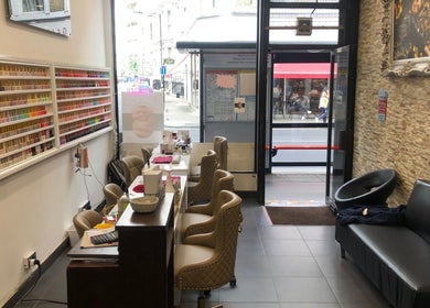 Interior of Ks Nail Salon in London, England, GB showcasing manicure stations and polish displays.
