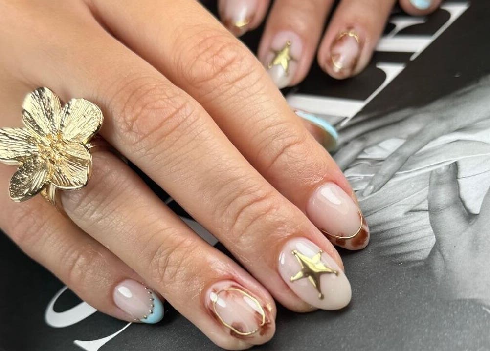 Diseño de uñas elegante en Mari.serene, Antofagasta, CL. Uñas con detalles dorados brillantes.