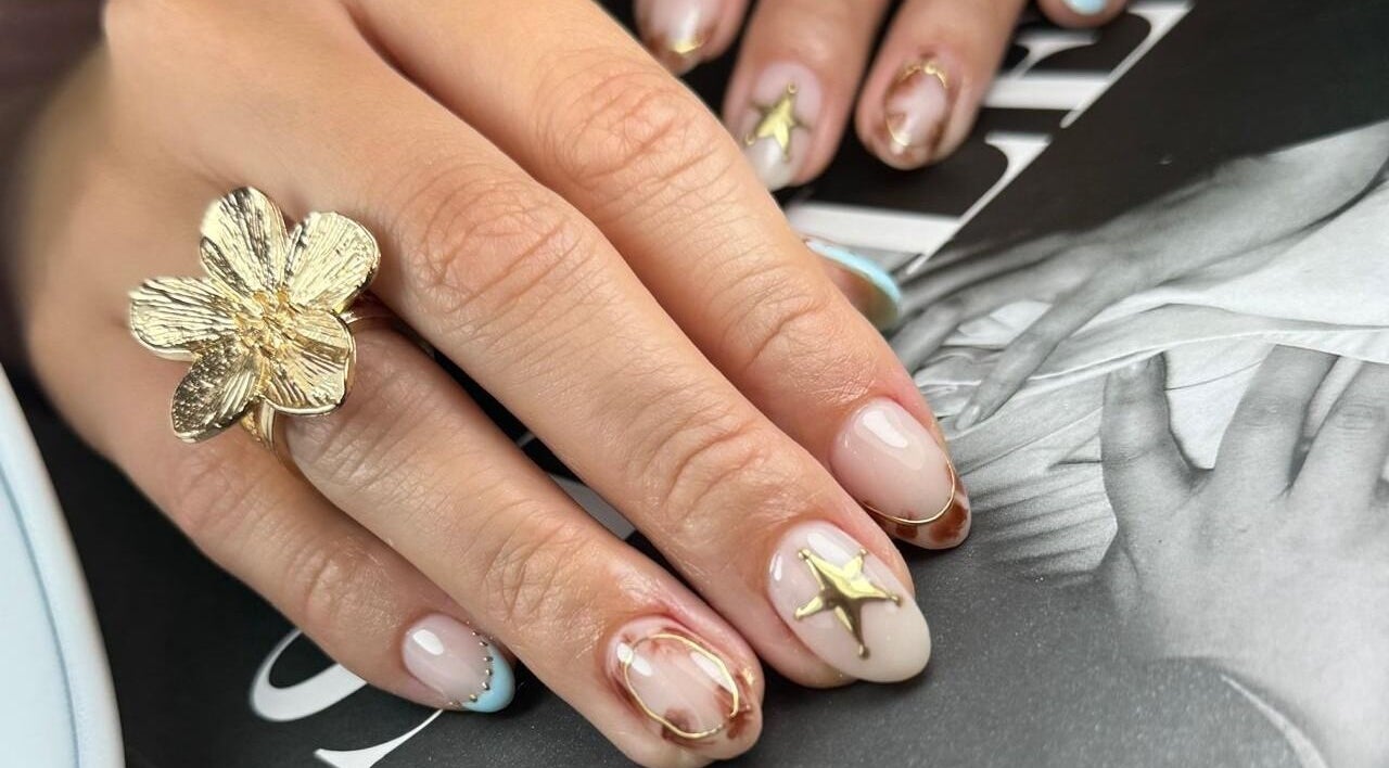 Diseño de uñas elegante en Mari.serene, Antofagasta, CL. Uñas con detalles dorados brillantes.