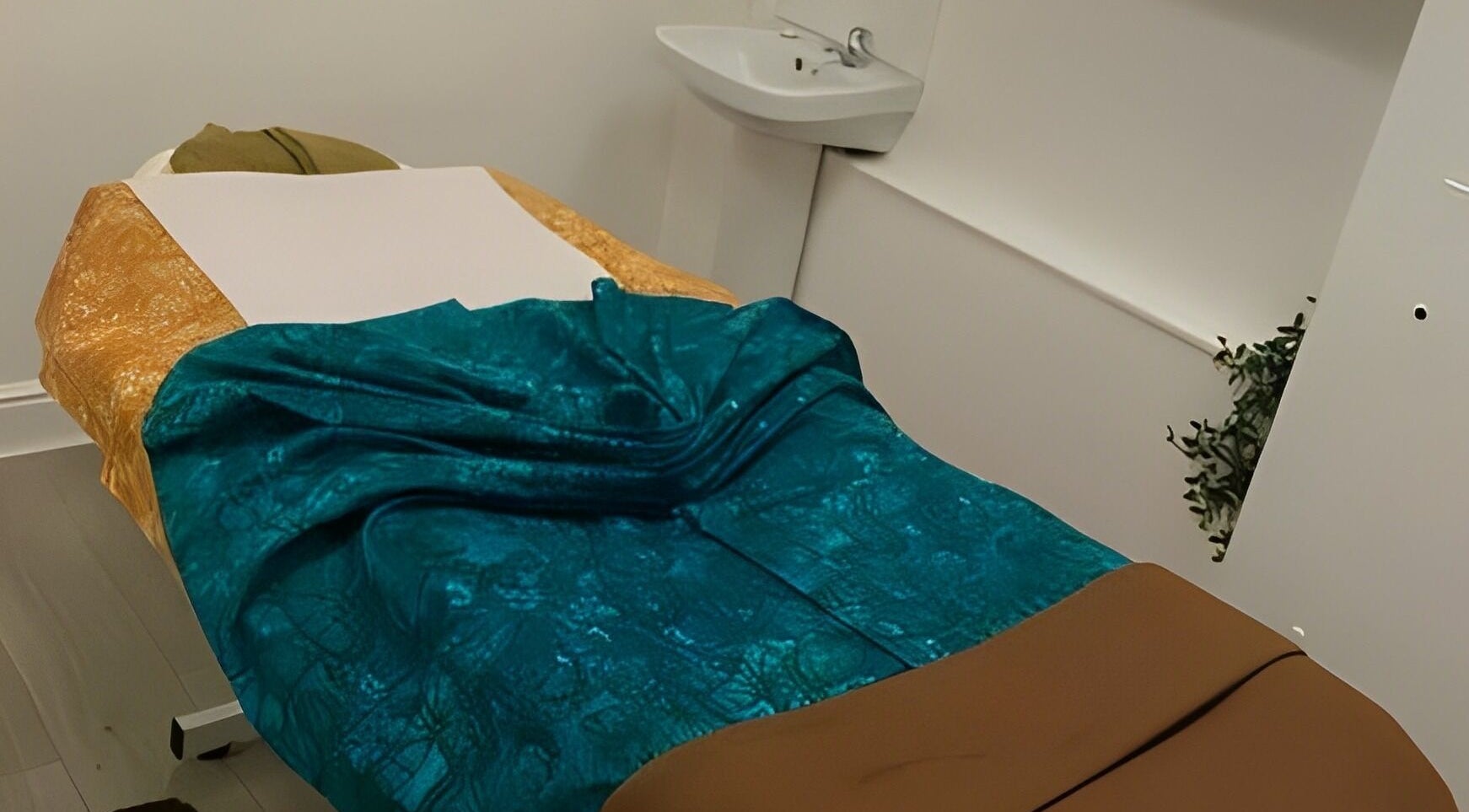 Relaxing massage room at Marialice Massage & Beauty, Stevenage, England, GB, with vibrant teal and gold decor.