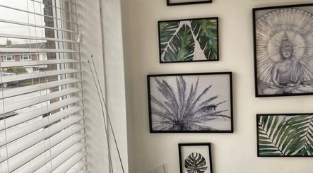 Art-filled corner at Marialice Massage & Beauty, Stevenage, England, GB, showcasing a serene Buddha and plant images.