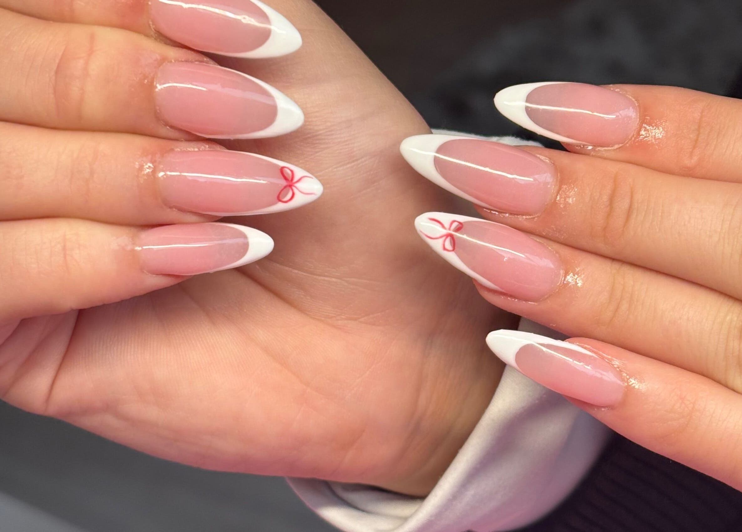 Elegant French manicure with red accents at NAILHAUS, Halifax, England, GB.