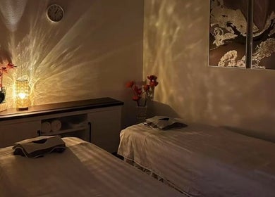 Cozy massage room at Sunny Massage Spa, Bentonville, Arkansas, US with warm lighting and floral decor.