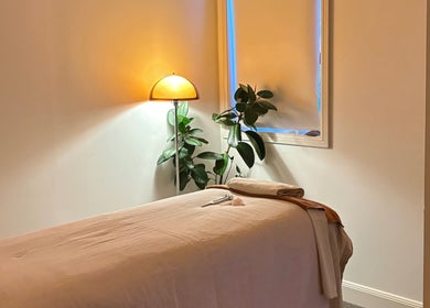 Tranquil massage room at Sound and Bodywork Massage in Melbourne, Victoria, AU featuring soft lighting and plants.