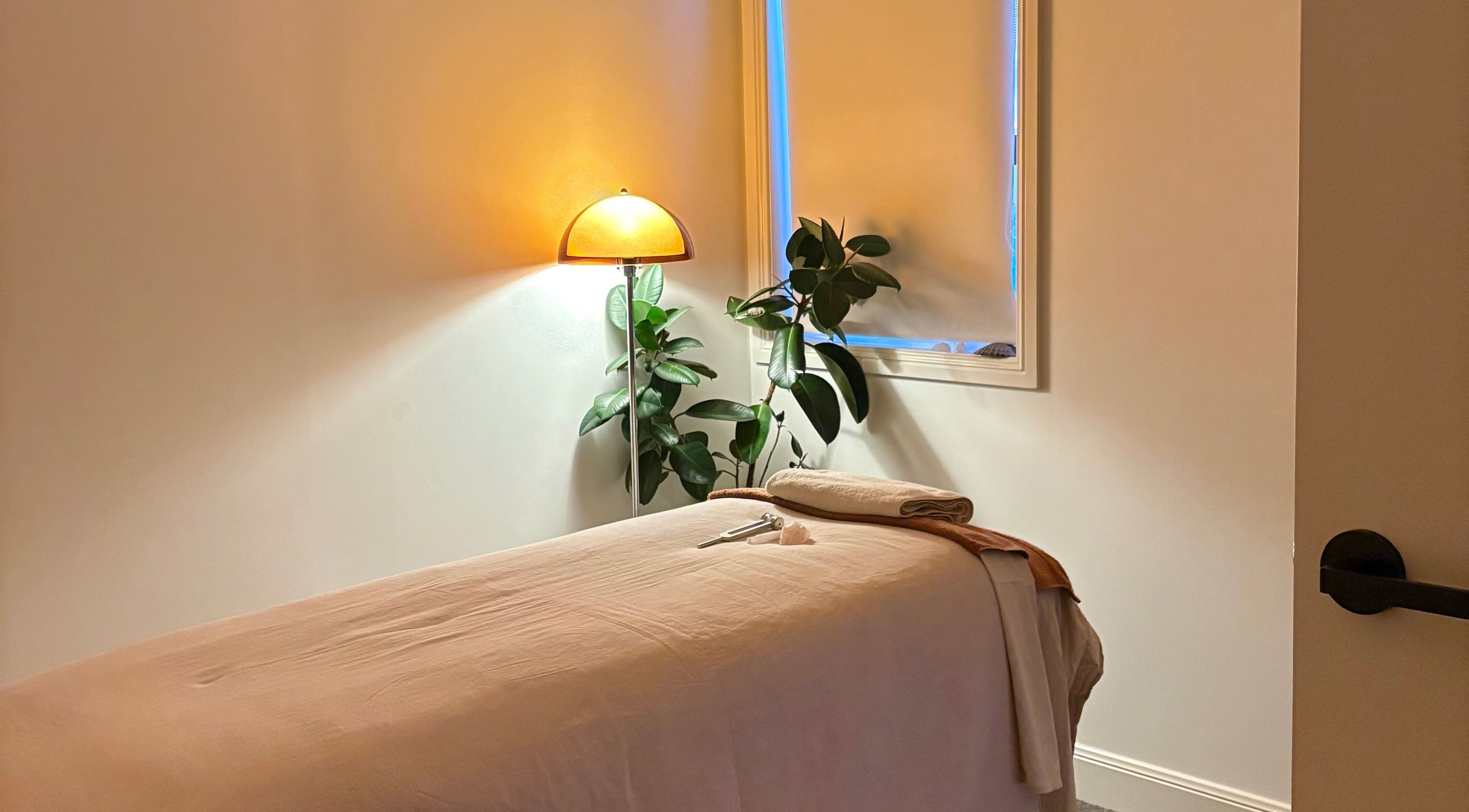 Tranquil massage room at Sound and Bodywork Massage in Melbourne, Victoria, AU featuring soft lighting and plants.