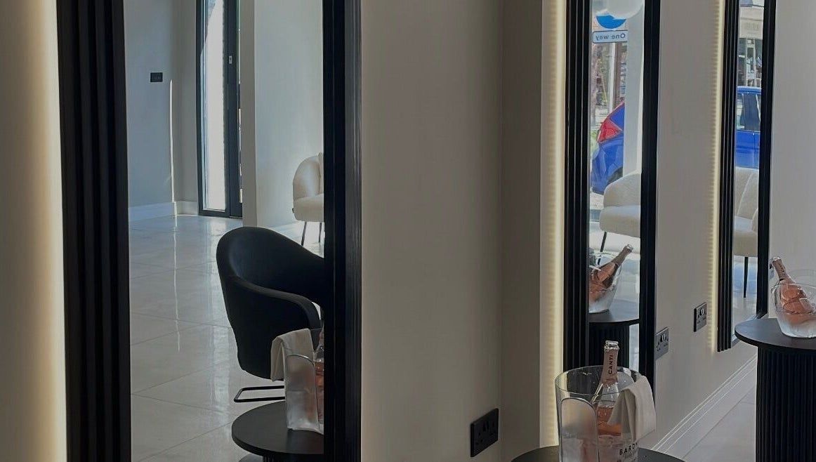 Modern salon interior at Becky With The Good Hair - Stubbington in Fareham, England, GB with sleek mirrors and chairs.