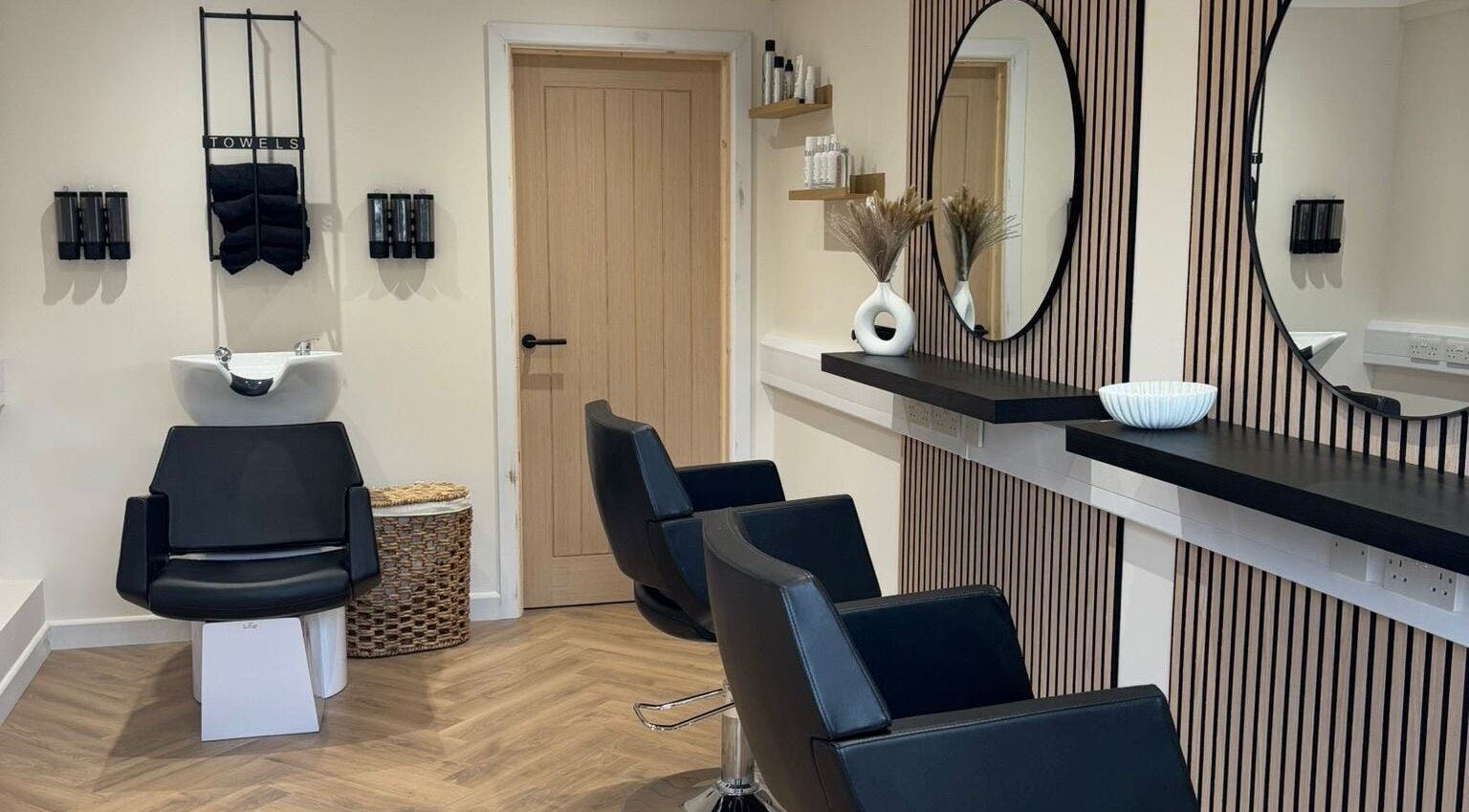 Modern salon interior at Becky With The Good Hair - West End, Southampton, GB, featuring stylish black chairs.