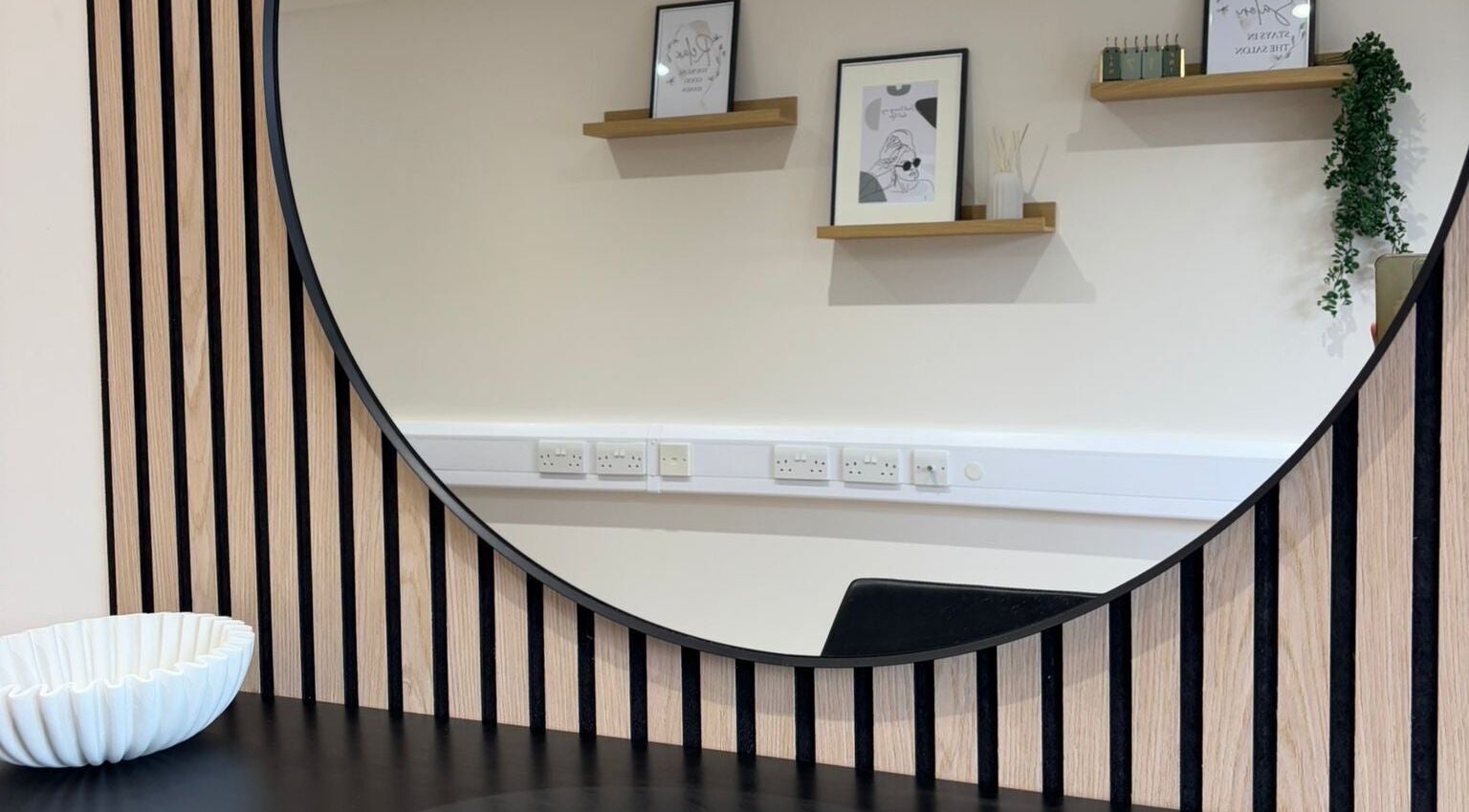 Stylish round mirror at Becky With The Good Hair - West End, Southampton, GB, reflecting elegant salon decor.