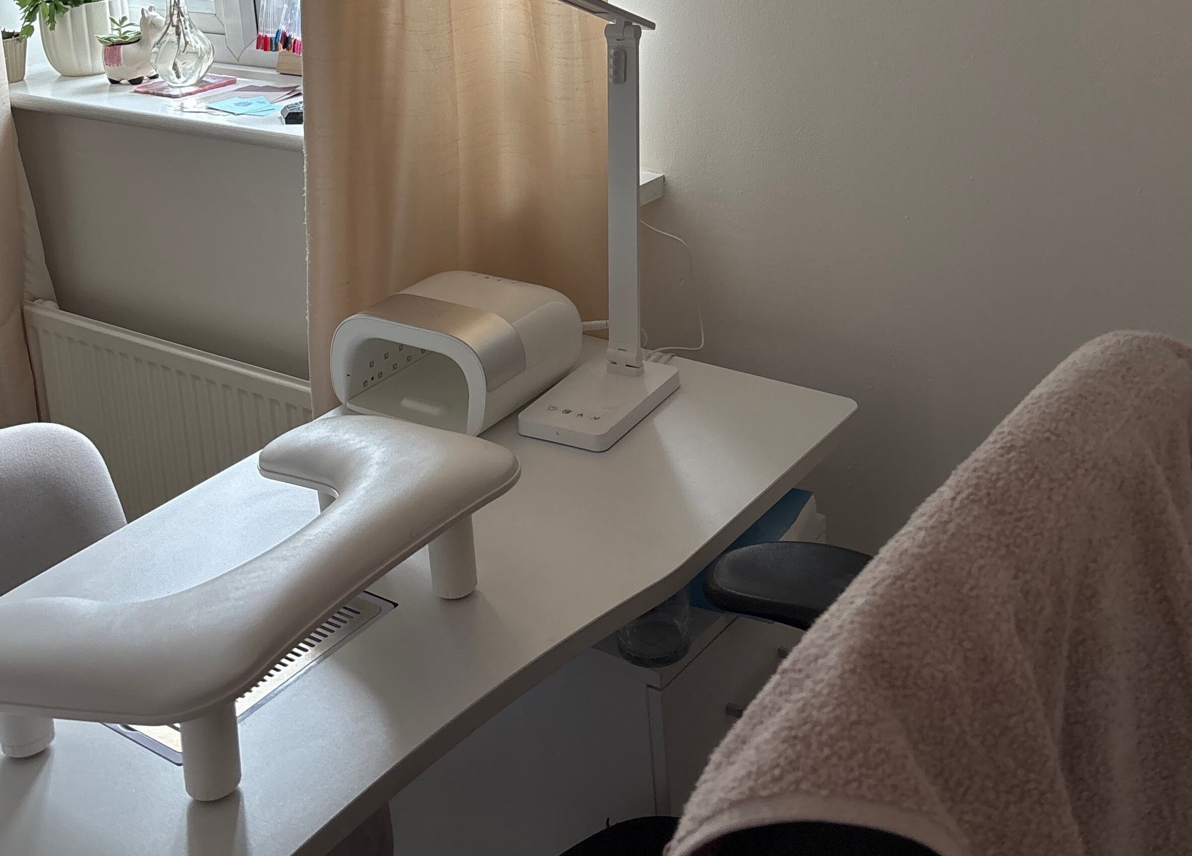 Serene nail desk setup at The Nail Room in Witchford, England, GB, featuring a modern lamp and manicure tools.