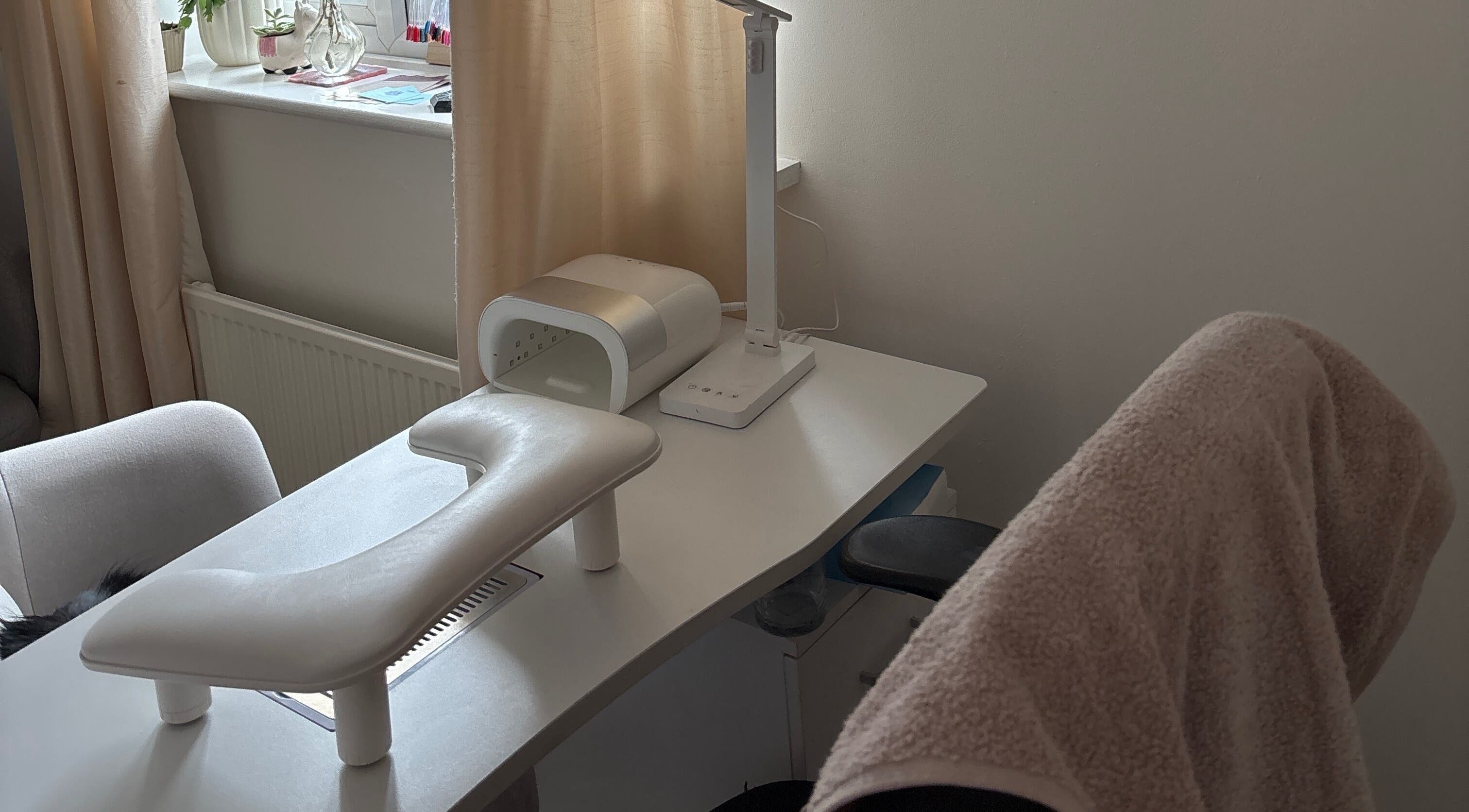 Serene nail desk setup at The Nail Room in Witchford, England, GB, featuring a modern lamp and manicure tools.